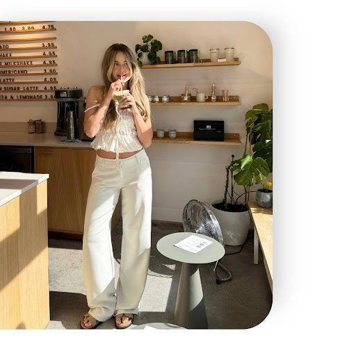 Vrouw draagt witte tall broek tijdens een koffie run